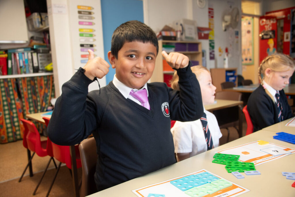 a picture of students doing puzzles with one with their thumbs up
